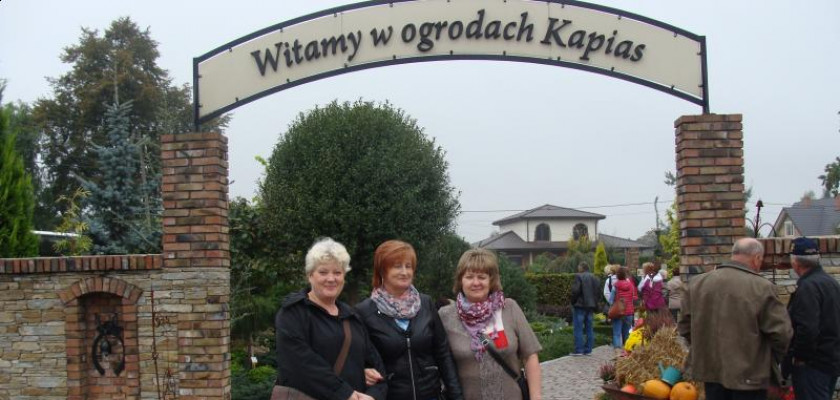 trójka kobiet stojąca w wejściu do ogrodów kapias