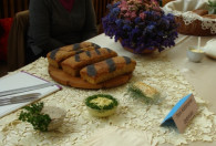 Zdjęcie przedstawia trzy chleby z makiem na drewnianej desce