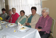 grupa starszych kobiet przy stole podczas obchodów dnia kobiet