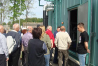 grupa ludzi wchodząca do zielonego budynku biogazowni