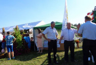 Zdjęcie przedstawia trzech Panów w białych koszulach przed stoiskiem PZDR Radomsko