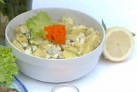 Sałatka ziemniaczana do potraw z grilla w białej misce ozdobiona marchewką